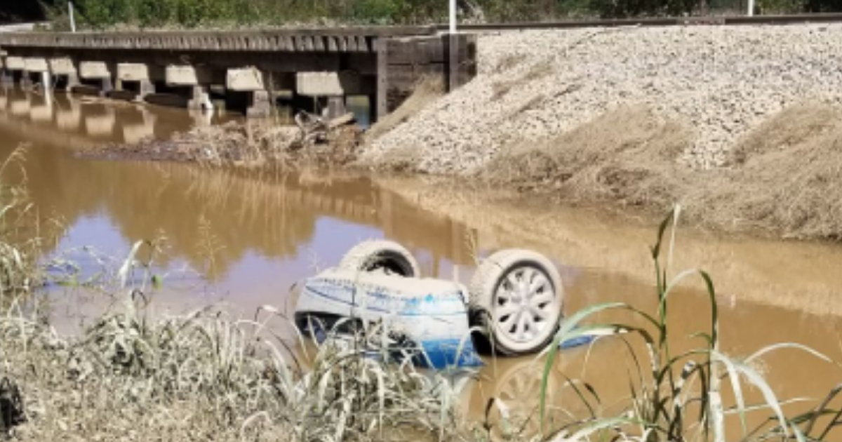 Car overturned in flood waters.