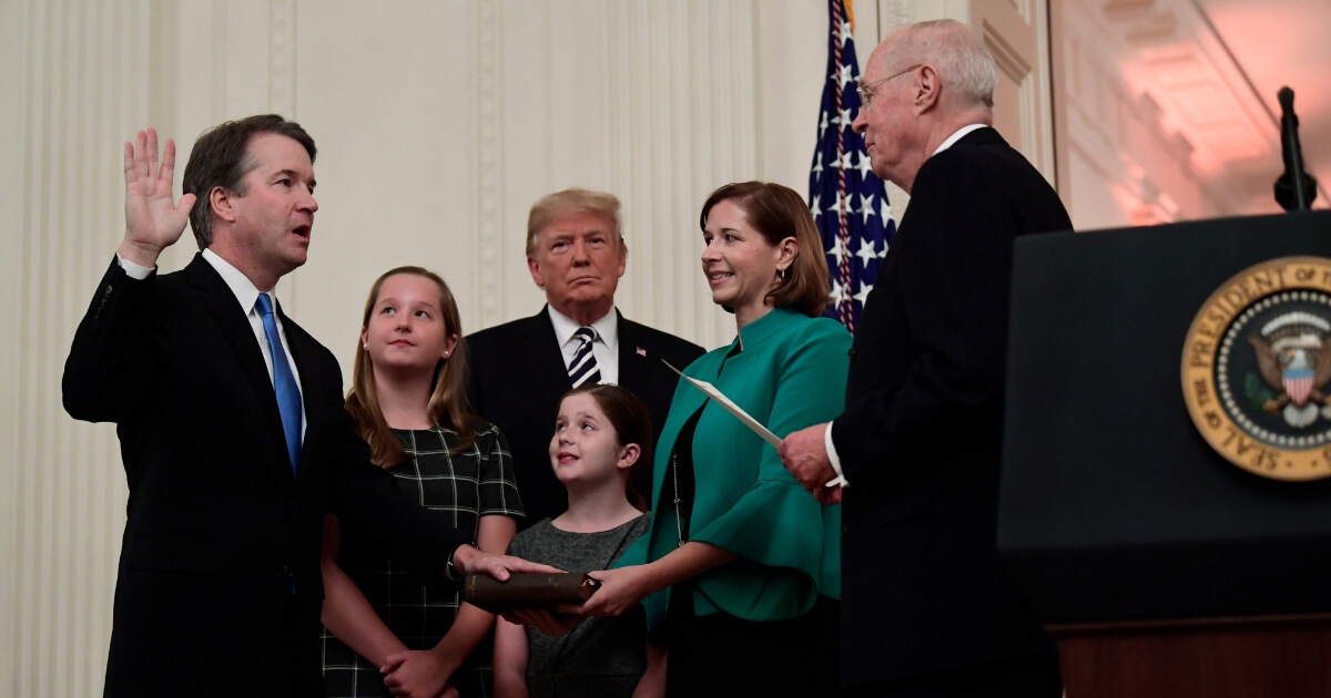 Retired Justice Anthony Kennedy ceremonially swears in Supreme Court Justice Brett Kavanaugh, as President Donald Trump looks on, in the East Room of the White House in Washington on Oct. 8, 2018. Ashley Kavanaugh holds the Bible and daughters Margaret and Liza look on.