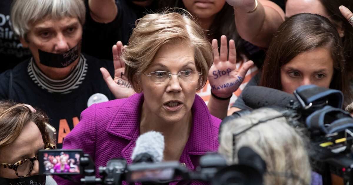 Sen. Elizabeth Warren, D-Mass., greets womens' rights activists in the Hart Senate Office Building as the Senate Judiciary Committee hears from Kavanaugh and Christine Blasey Ford, his accuser, on Capitol Hill in Washington, Sept. 27, 2018.