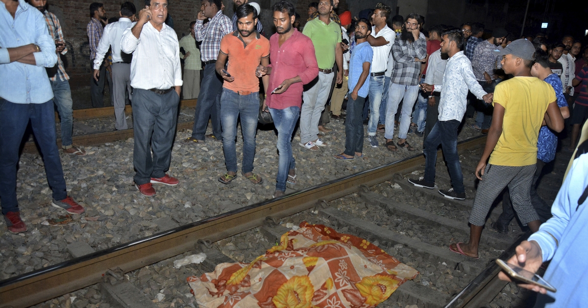The body of a victim of a train accident lies covered in cloth on a railway track in Amritsar, India, on Friday.