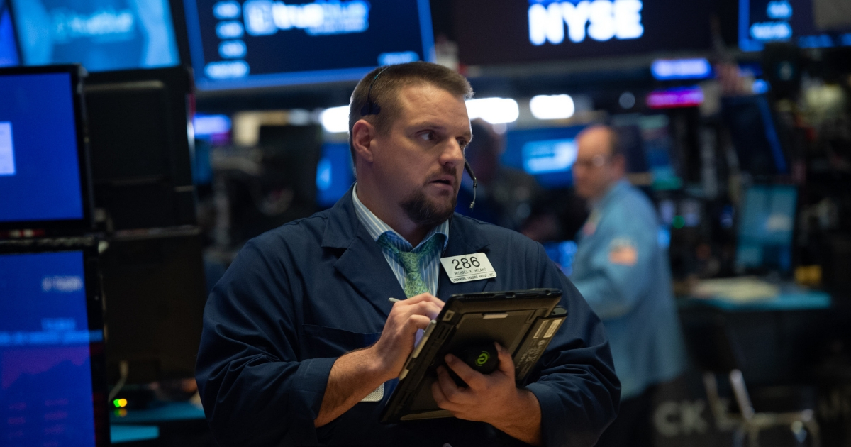 Traders work the floor at the closing bell of the Dow Industrial Average