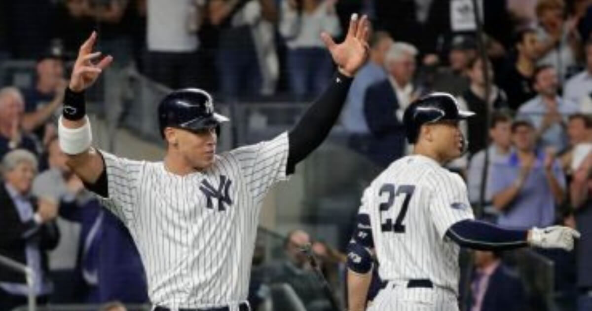New York Yankees' Aaron Judge, left, reacts after scoring on a double by Aaron Hicks during the sixth inning of the American League wild-card game Wednesday in New York.