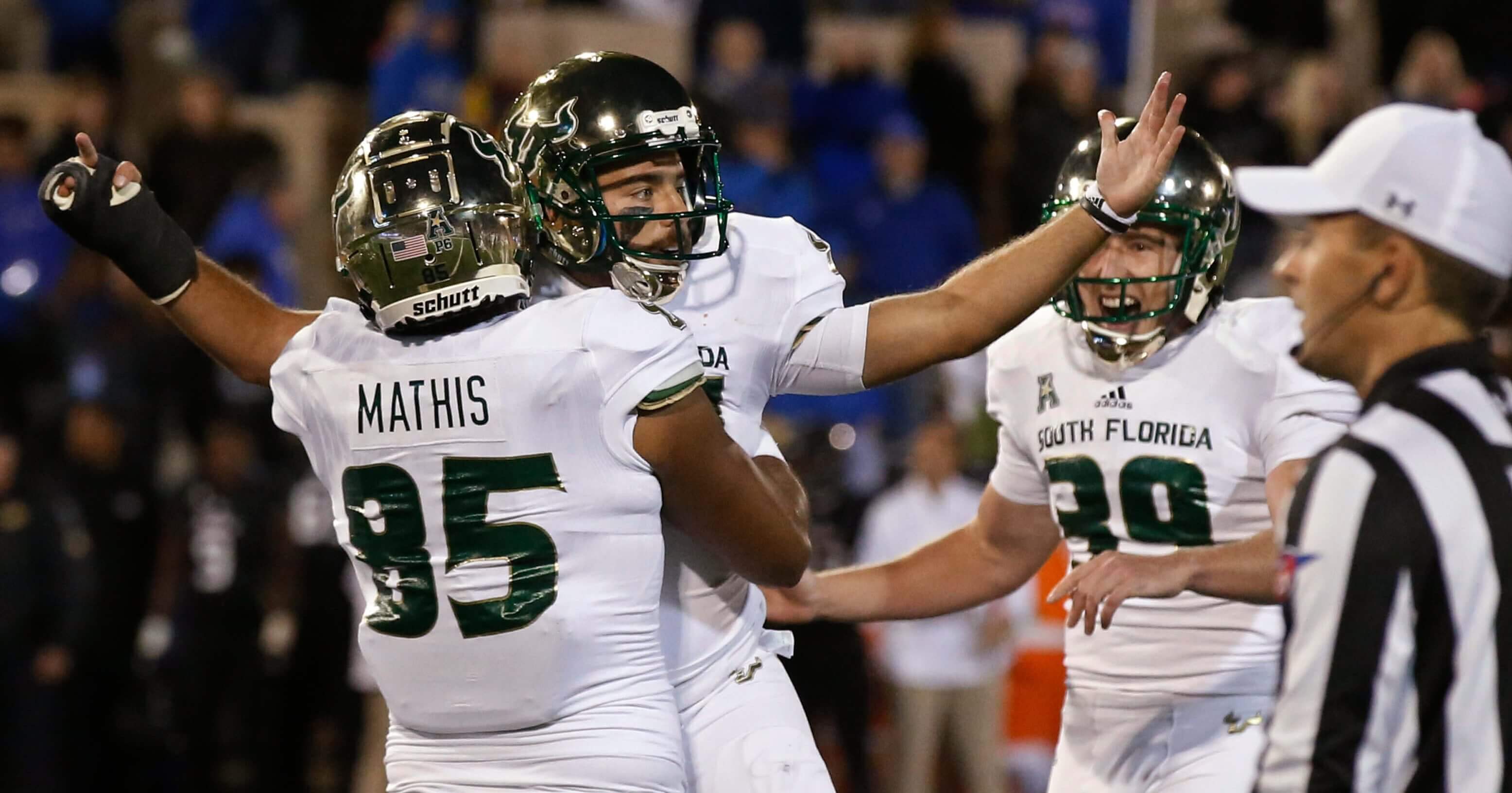South Florida's Coby Weiss, center, celebrates with teammates Jacob Mathis (85) and Trent Schneider (39) after kicking the go-ahead field goal in a game against Tulsa on Friday night.