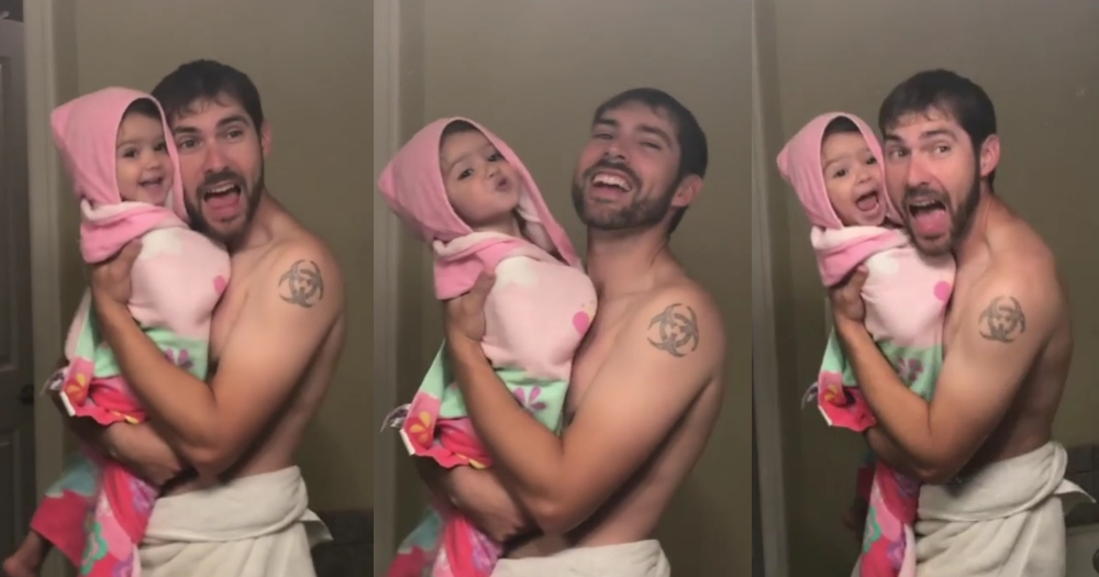 A dad sings in the mirror with his daughter.