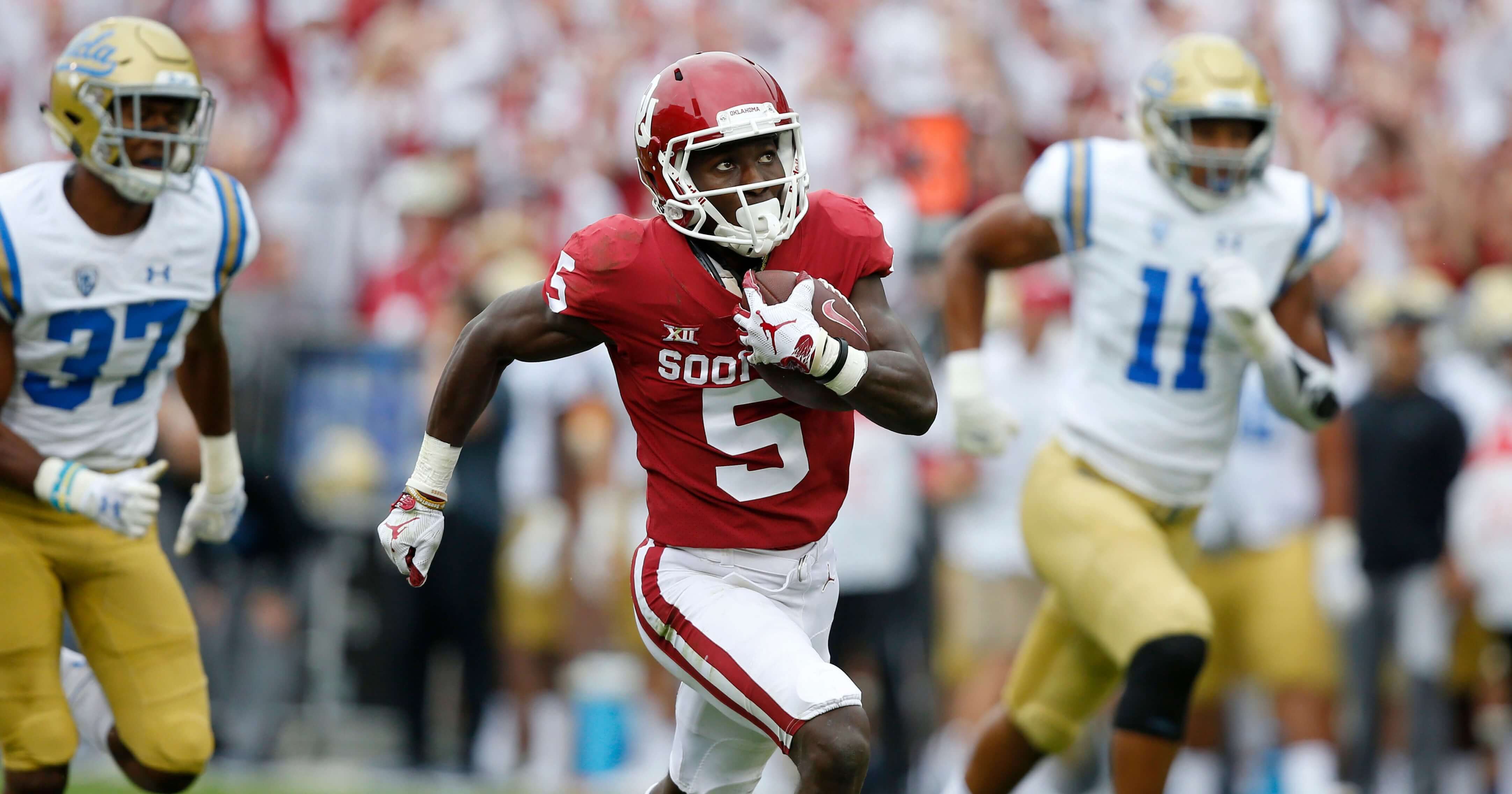 Oklahoma wide receiver Marquise Brown runs away from UCLA defensive back Quentin Lake (37) and linebacker Keisean Lucier-South (11) for a touchdown in the first quarter of their Sept. 8 game in Norman.