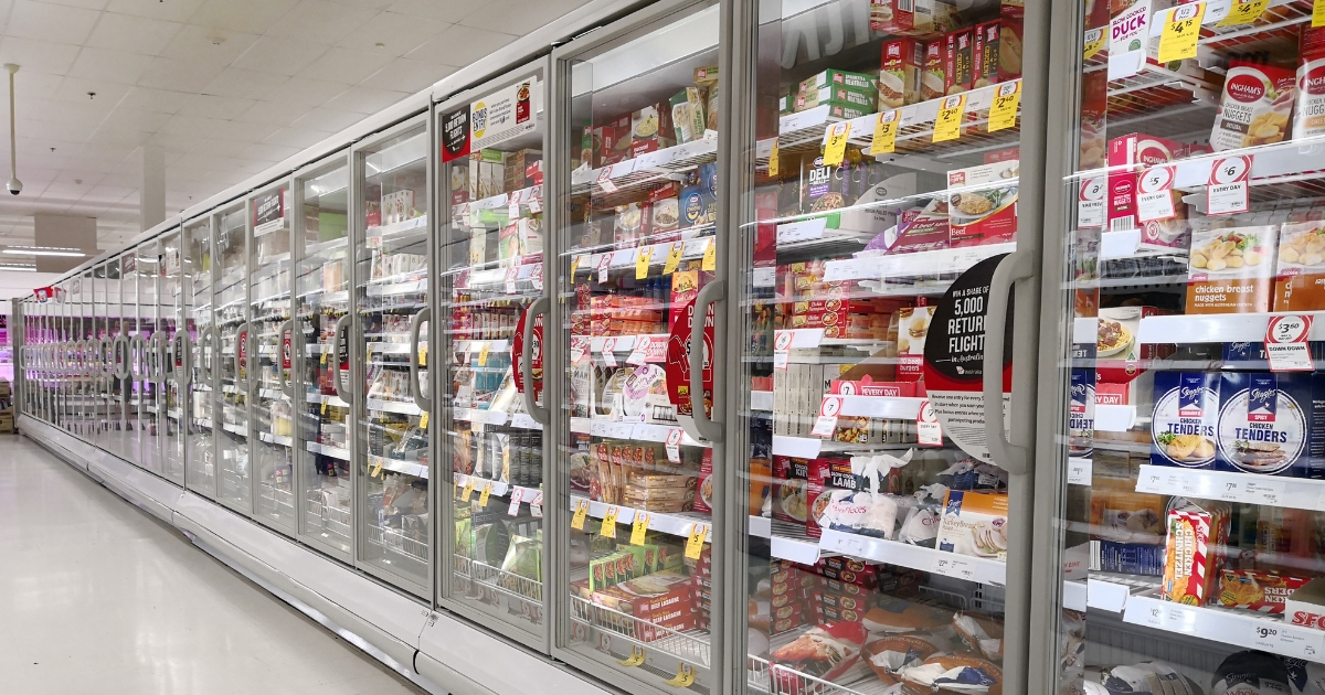 Interior view of huge glass freezer with various brand frozen foods.