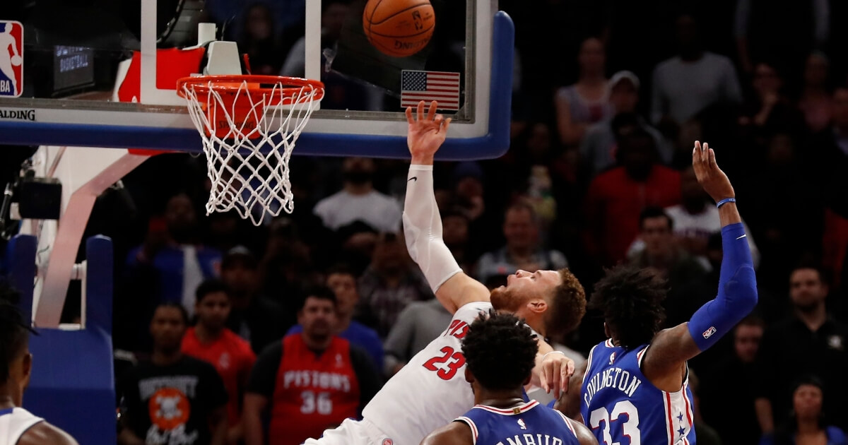 Detroit Pistons forward Blake Griffin (23) is fouled by Philadelphia 76ers forward Robert Covington (33) as he makes the basket to tie the game in overtime Tuesday in Detroit.