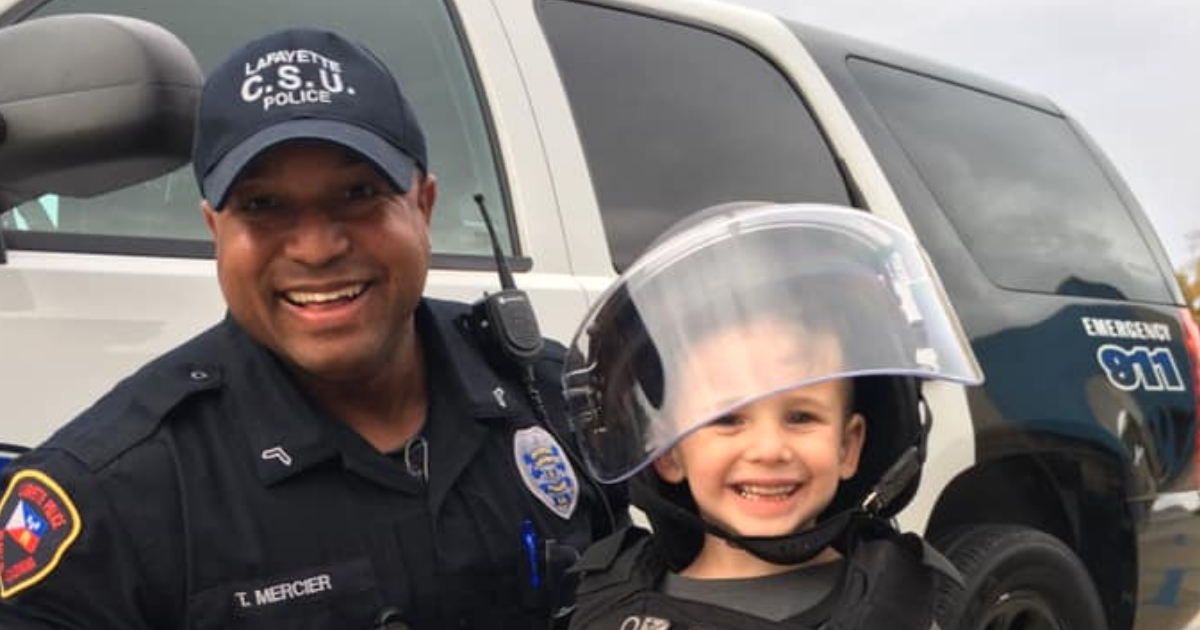 Little boy in police outfit with police officer.