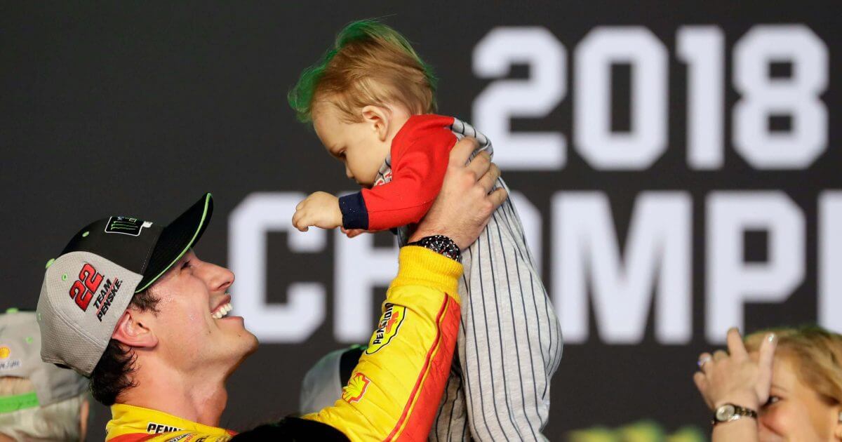 Joey Logano holds his son Hudson after winning the NASCAR Cup Series Championship