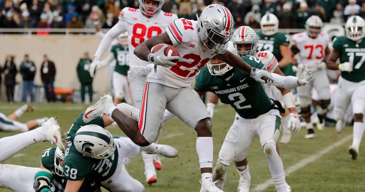 Ohio State wide receiver Parris Campbell (21) leaps over Michigan State linebacker Byron Bullough (38) to score on a 1-yard run Saturday in East Lansing, Michigan.