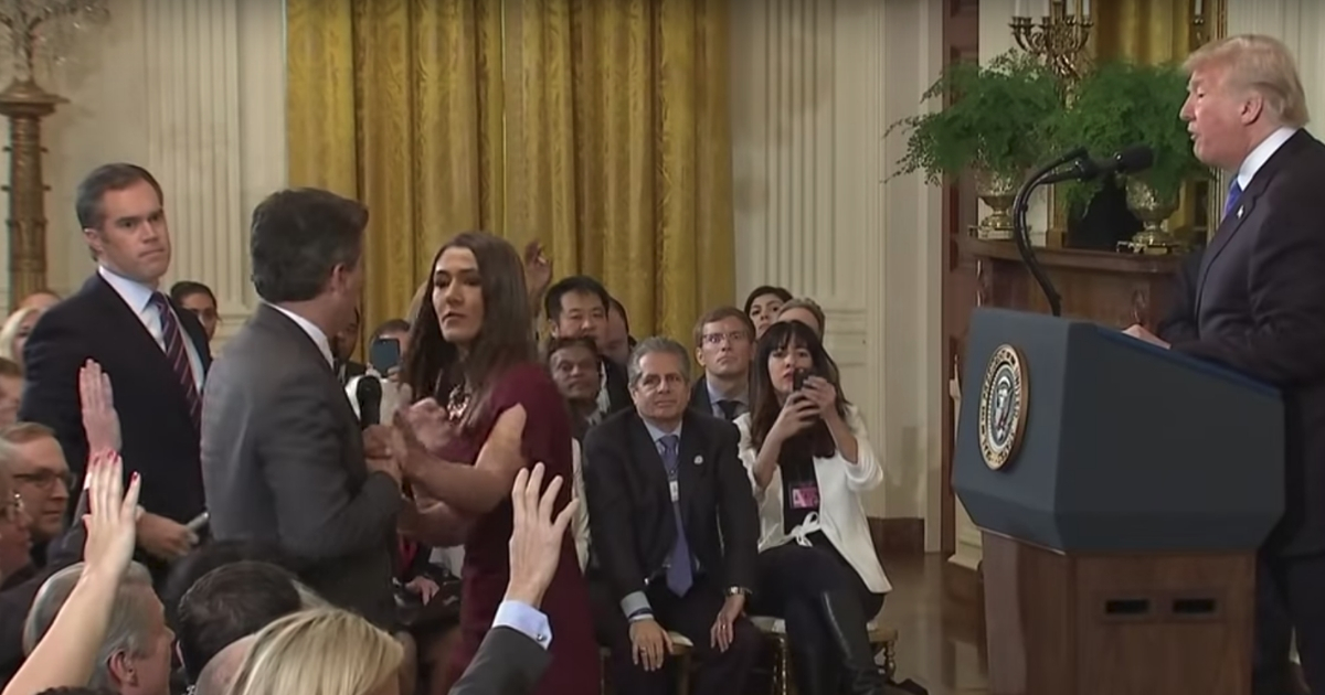 CNN's Jim Acosta, far left, tries to prevent a White House aide from taking a microphone from him during a press briefing at the White House on Wednesday.