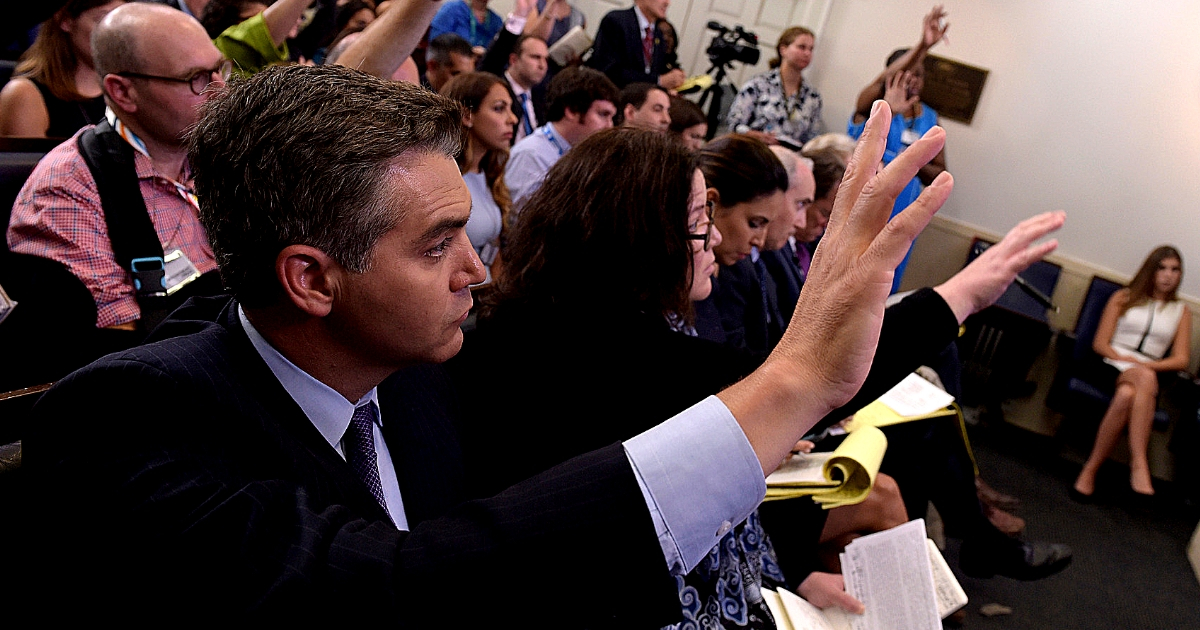 Jim Acosta of CNN raises his hand to ask a question during a press briefing at the White House.