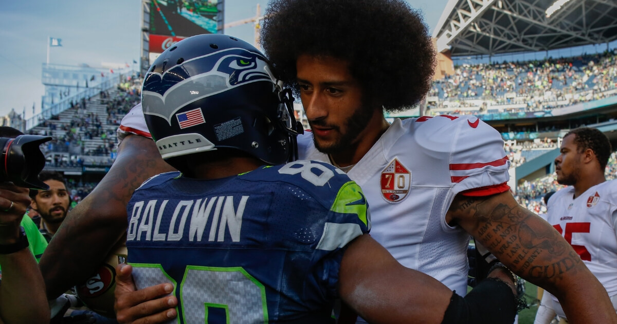 Then-San Francisco 49ers quarterback Colin Kaepernick embraces Seattle Seahawks wide receiver Doug Baldwin after a game Sept. 25, 2016.