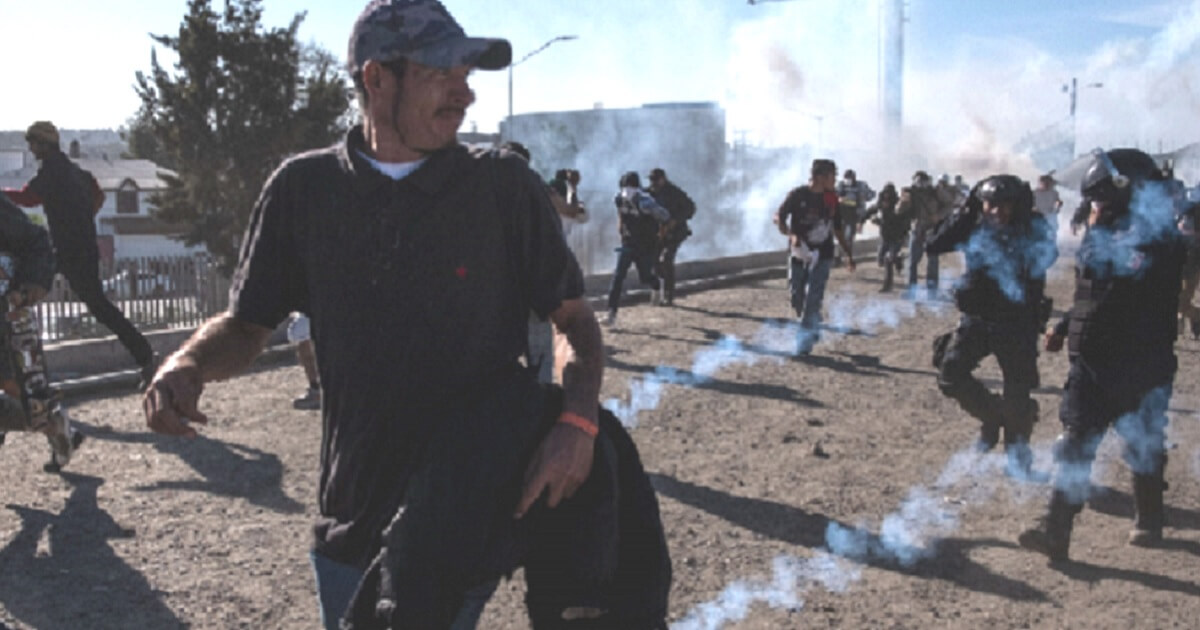 Migrants with the Central American caravan at the Mexican-U.S. border flee tear gas fired by the American Border Patrol on Sunday.