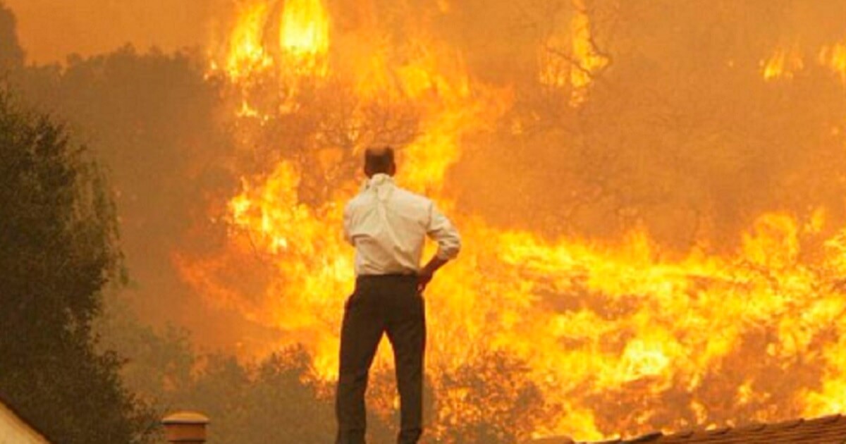 A man stands in front of a huge wall of flame in a Twitter post published by conservative radio and TV host Sean Hannity on Tuesday.