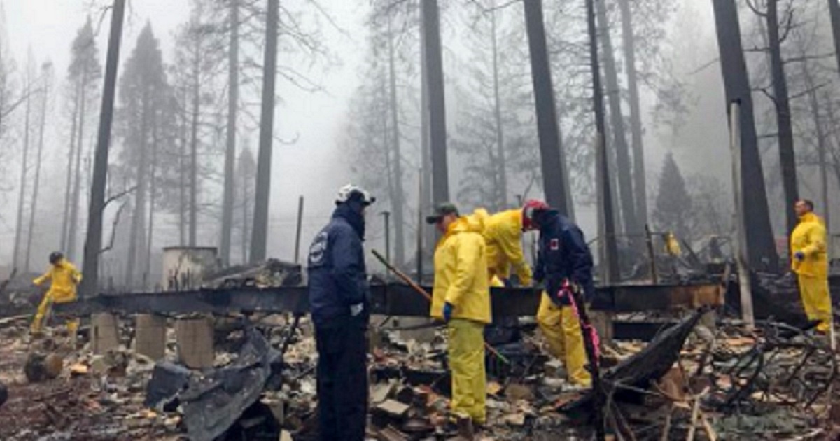 Firefighters stand amid the devastation of California's Camp Fire, a huge blaze with a death toll that reached 87 and could go higher.