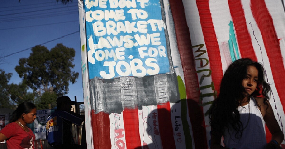 A sign at the migrant caravan claims the migrants don't want to break the law, just get jobs.