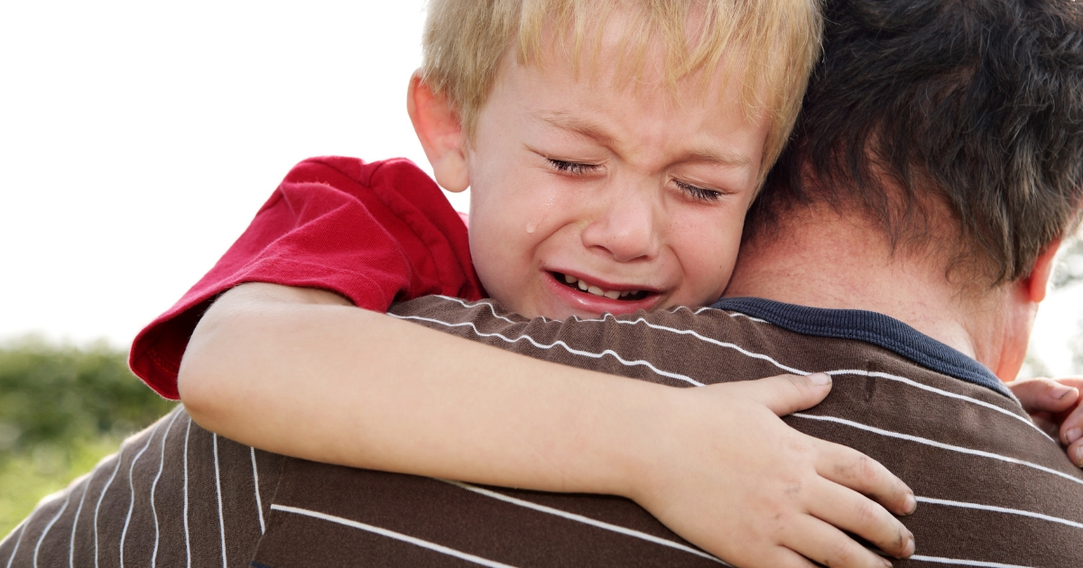 Crying Boy in Father's Arms