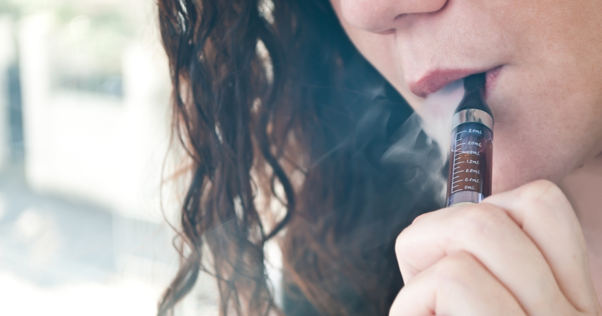 A young woman smoking an electronic cigarette.