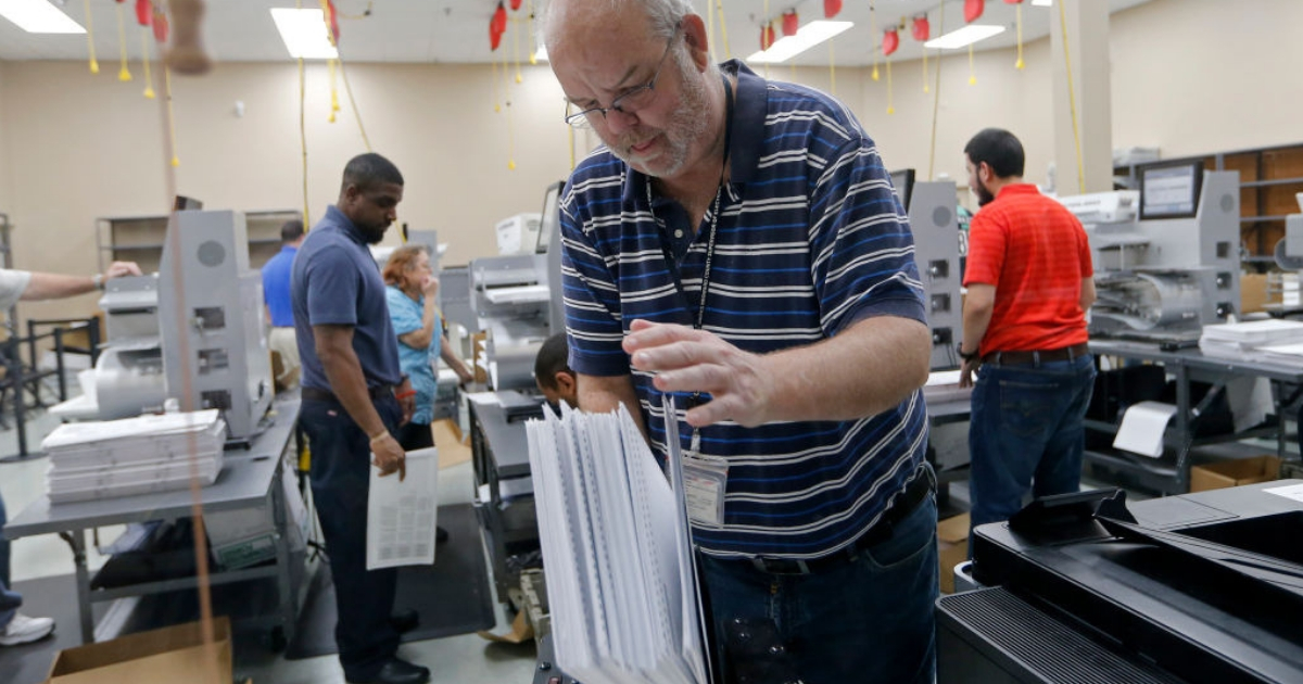A device is used to straighten ballots before machine counting during a recount at the Broward County Supervisor of Elections office