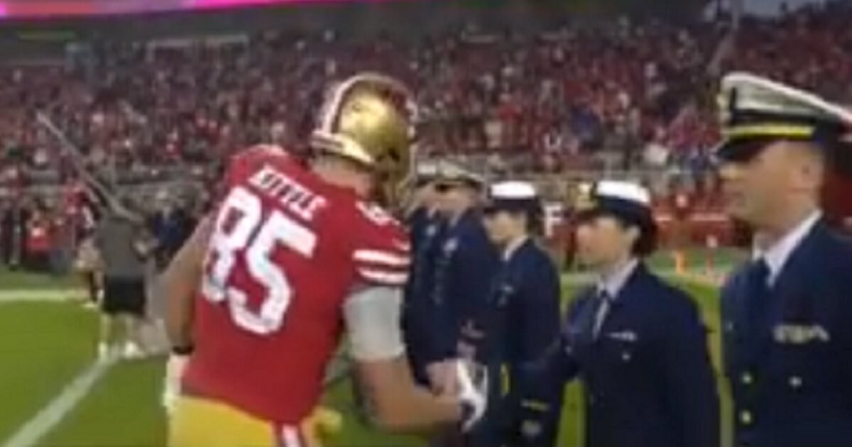 San Francisco tight end George Kittle shakes hands with servicemen and women prior to Monday night's game.