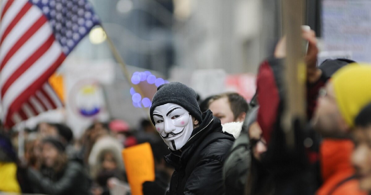 An anti-Trump protester wears a Guy Fawkes mask at a demonstration outside Trump Tower in Toronto in November 2016.