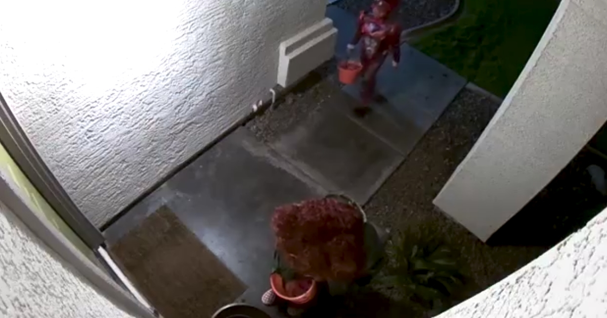Little girl puts candy back into halloween bowl