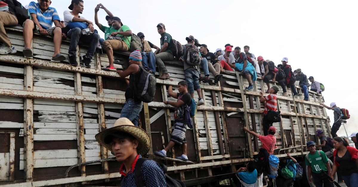 Members of a U.S.-bound migrant caravan board a truck on the road after Mexico's federal police briefly blocked them outside the town of Arriaga, Oct. 27, 2018.