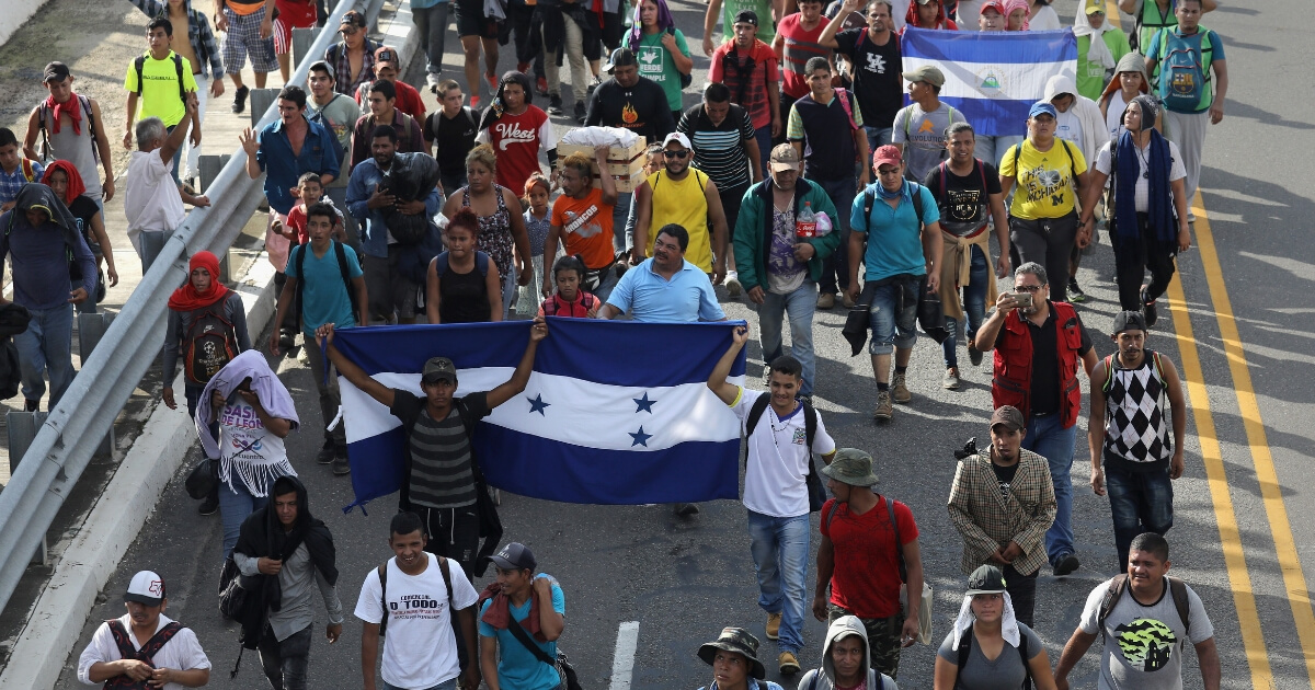 Members of the migrant caravan carry flags of Honduras, left, and Nicaragua as they head toward the U.S. border in October.