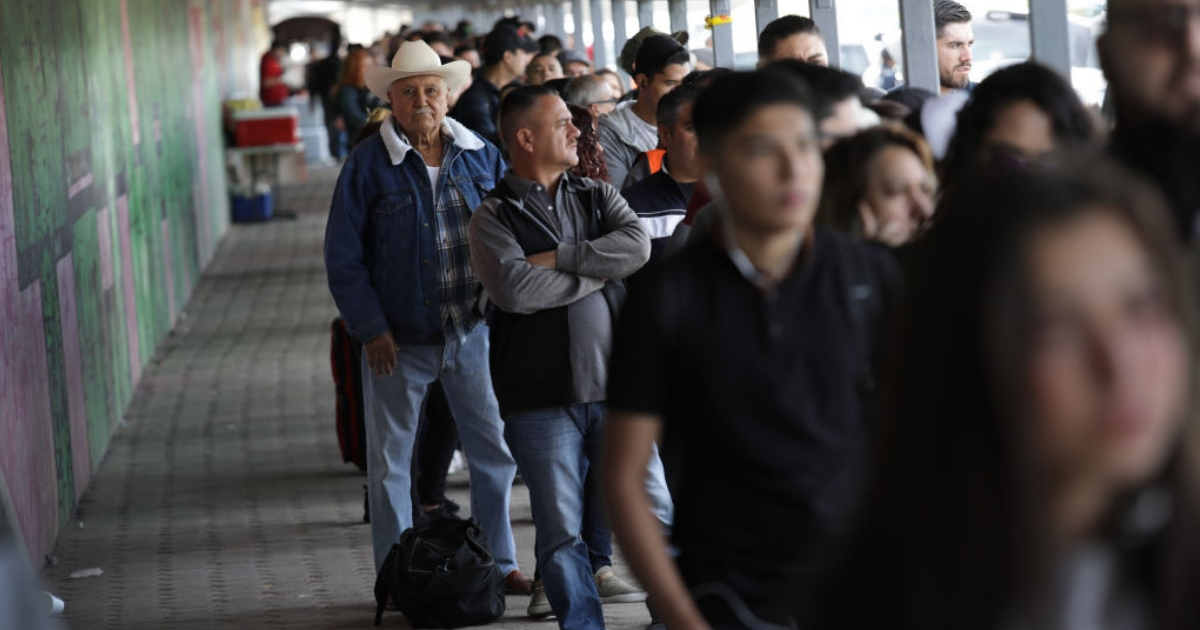 People wait to cross from Mexico into the United States