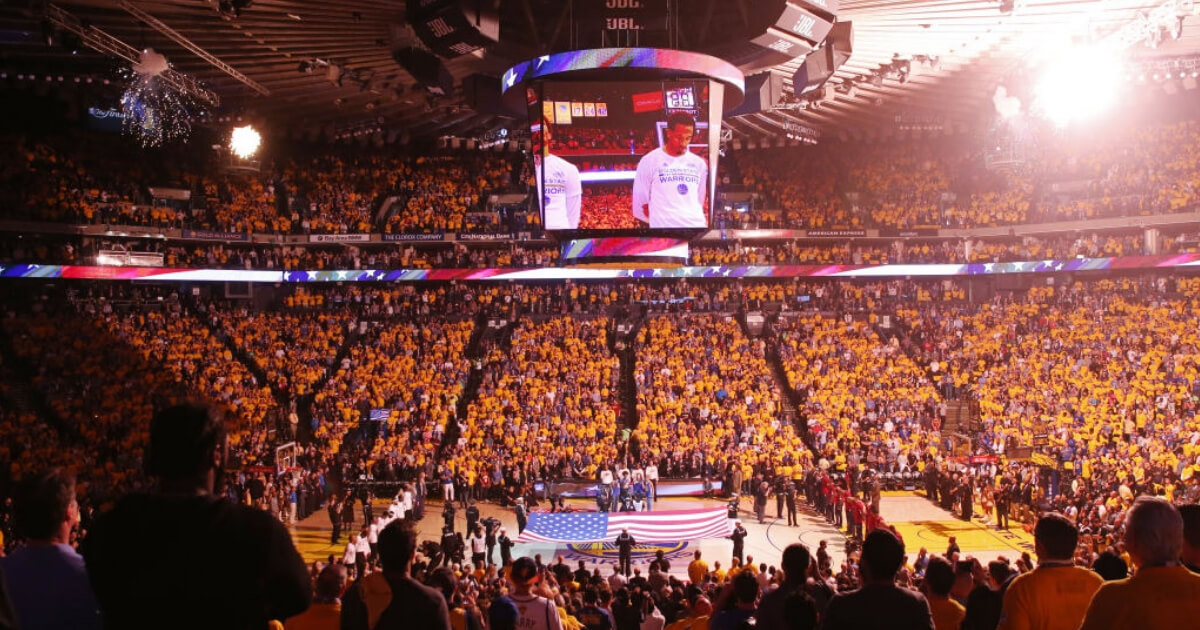 The crowd stands for the national anthem prior to an NBA game at Oracle Arena