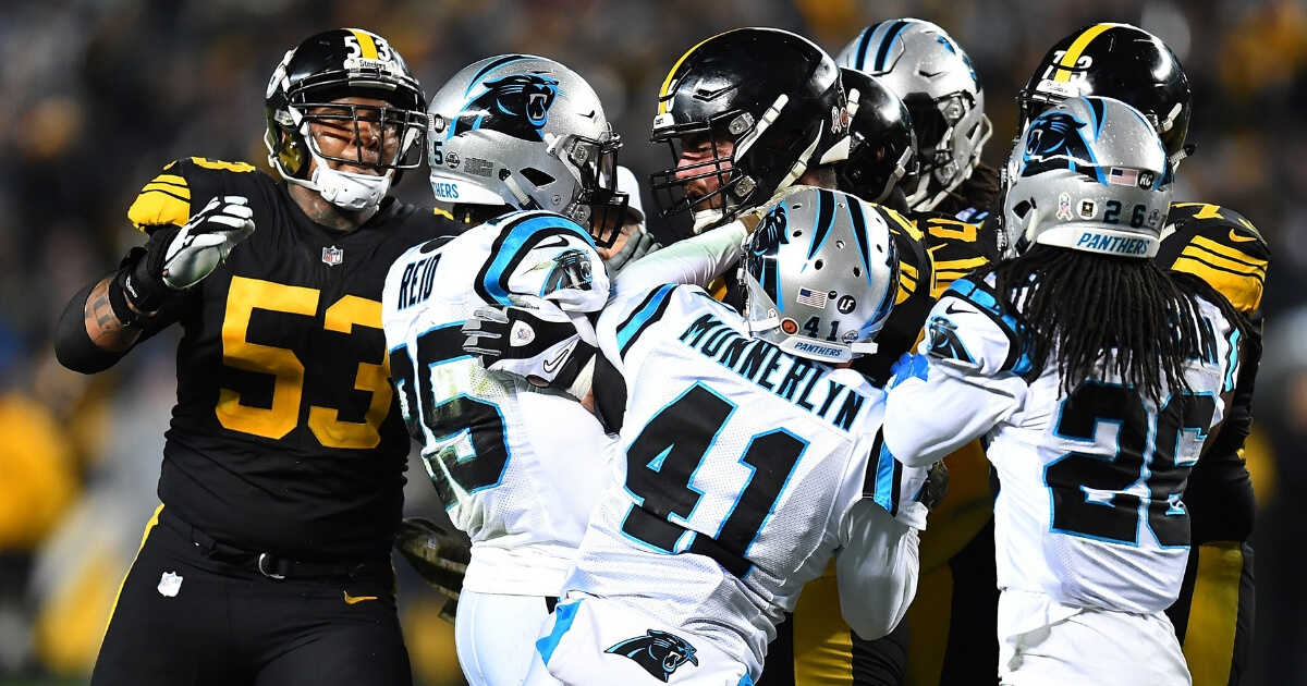 David DeCastro of the Pittsburgh Steelers shoves Eric Reid of the Carolina Panthers after a late hit on quarterback Ben Roethlisberger during their game Thursday night at Heinz Field.