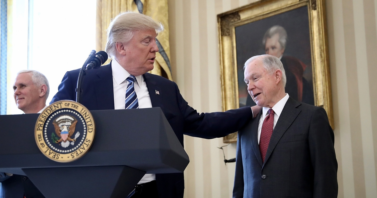 U.S. President Donald Trump (C) put his hand on the shoulder of Sen. Jeff Sessions (R)