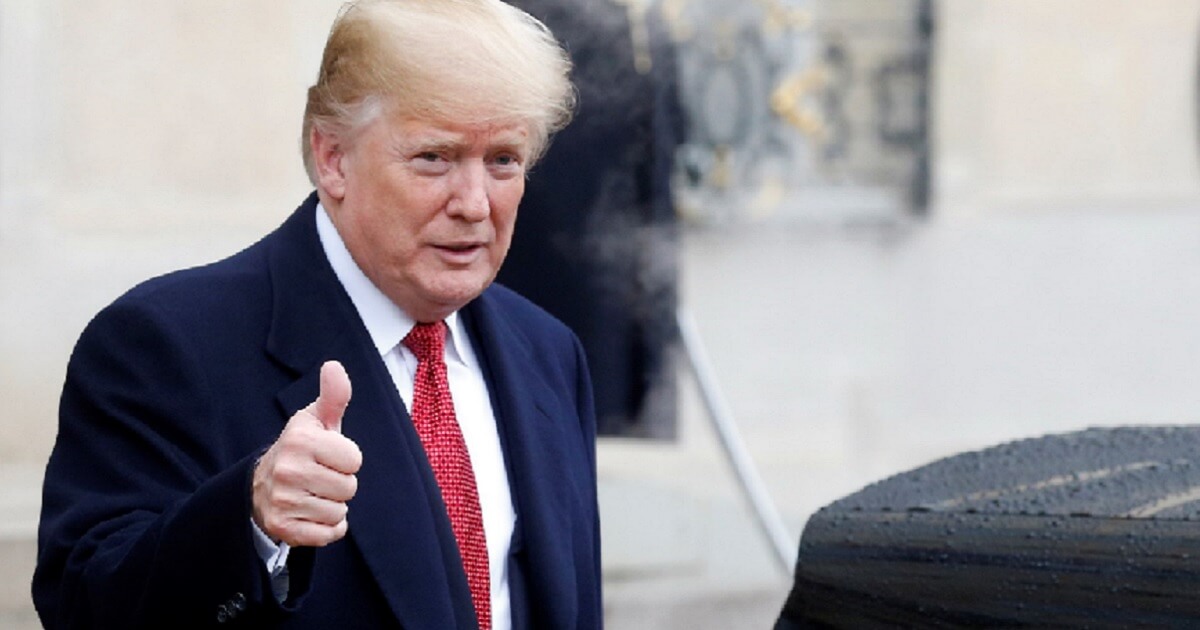 President Donald Trump gives a thumbs-up sign in Paris.