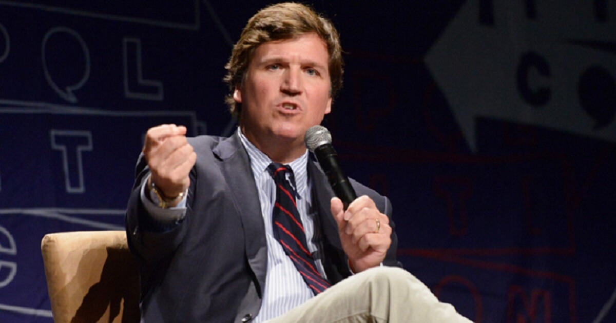Fox News' Tucker Carlson appears to make a fist as he makes a point during Politicon 2018 on Oct. 21 at the Los Angeles Convention Center.