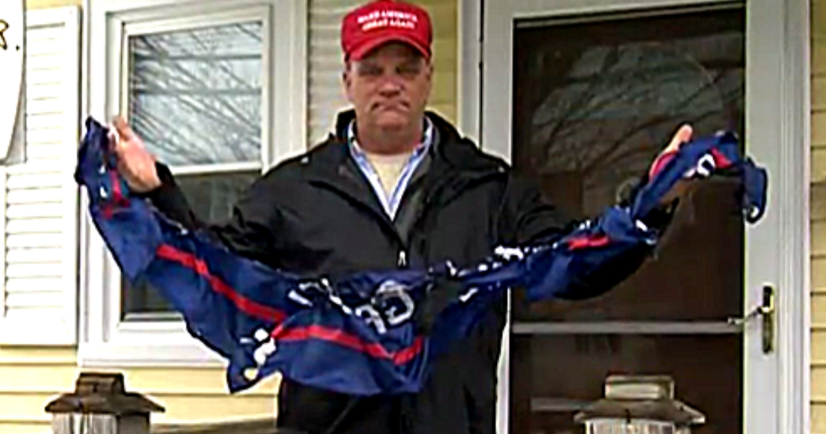 Military veteran Gus Kline holds the 'Trump 2020' flag that vandals took down and burned on his property.