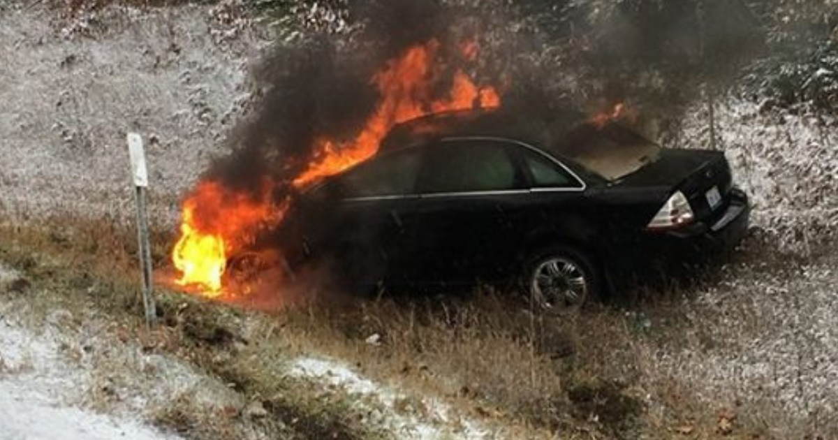 A black car with the engine on fire.