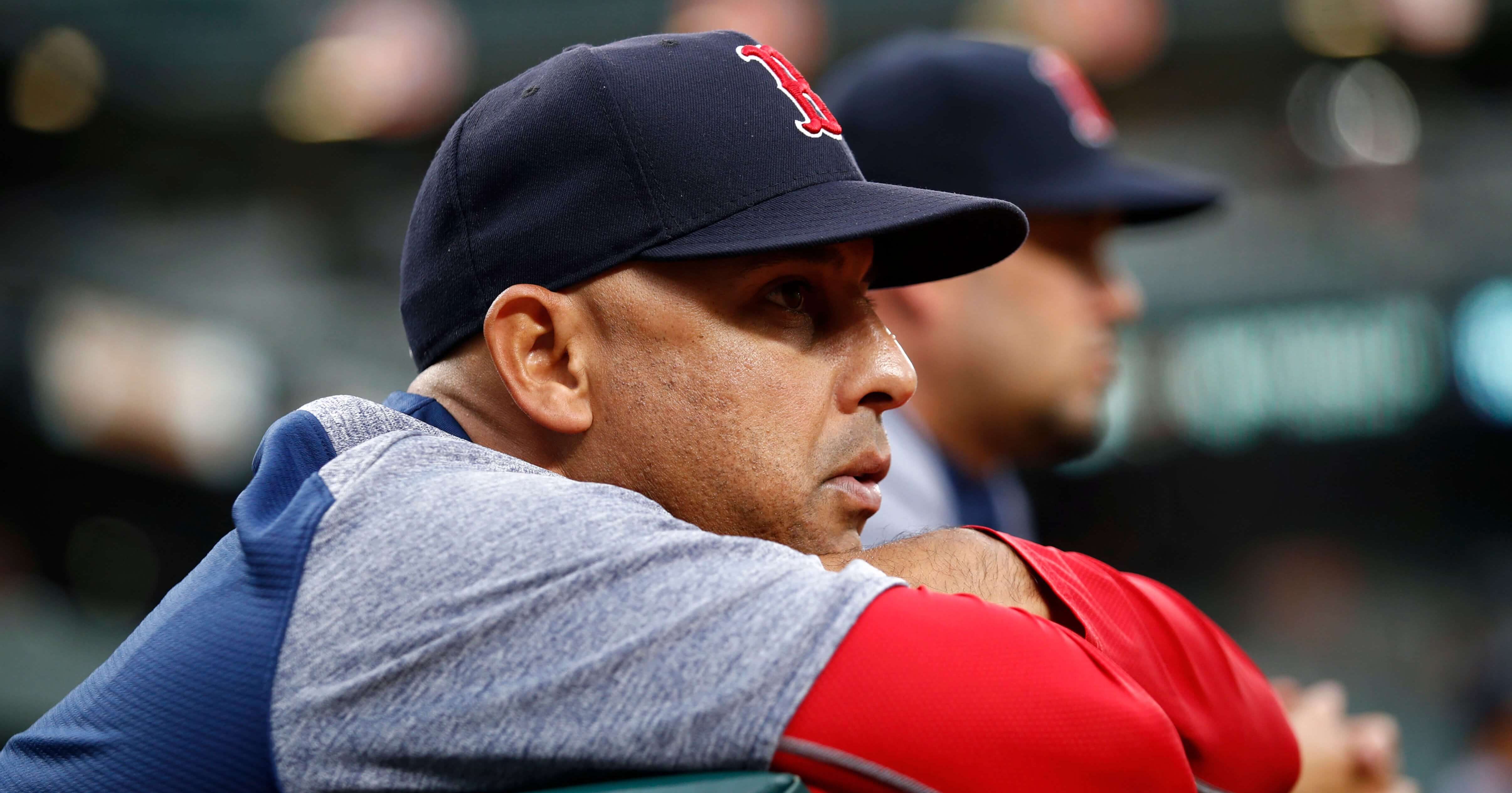 ston Red Sox manager Alex Cora leans against the dugout rail during the second inning of a July game against the Baltimore Orioles.