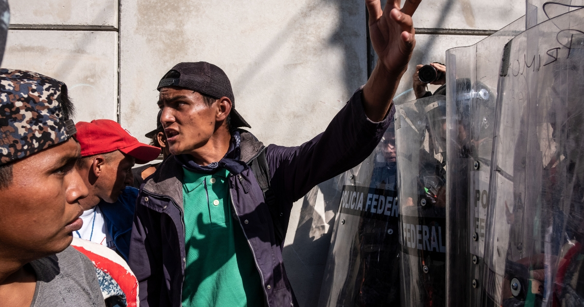 Mexican Police officers block the way to Central American migrants