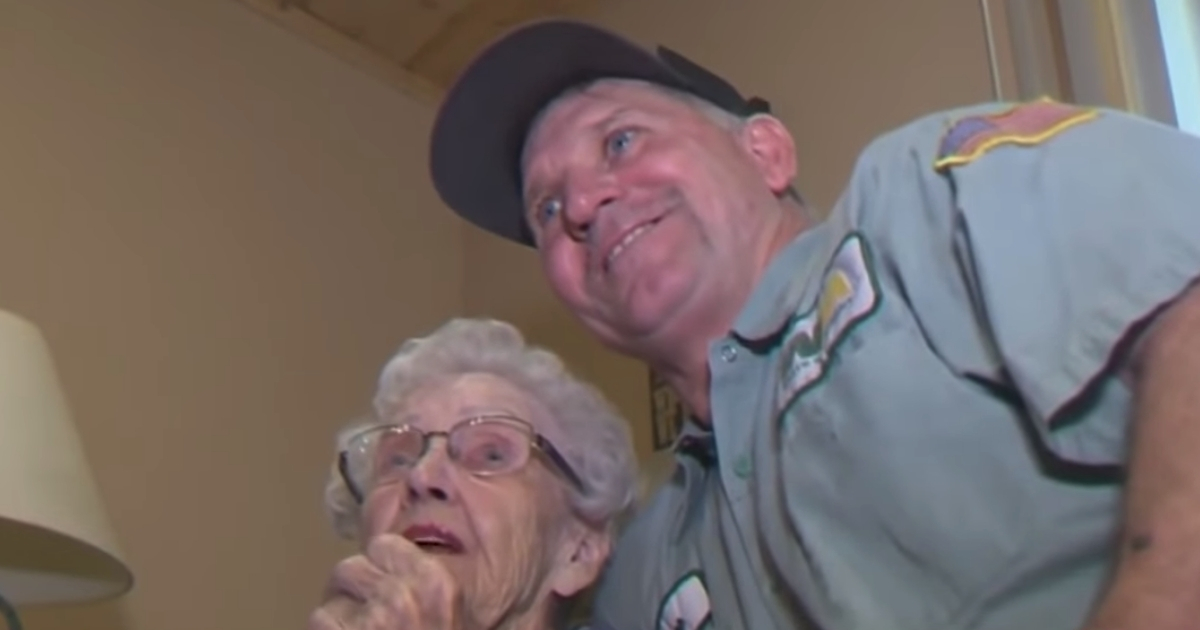 An elderly woman and a waste management employee.