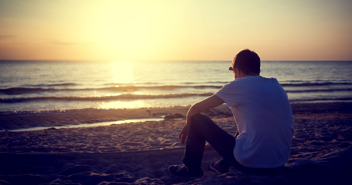 Man sitting alone on the beach.