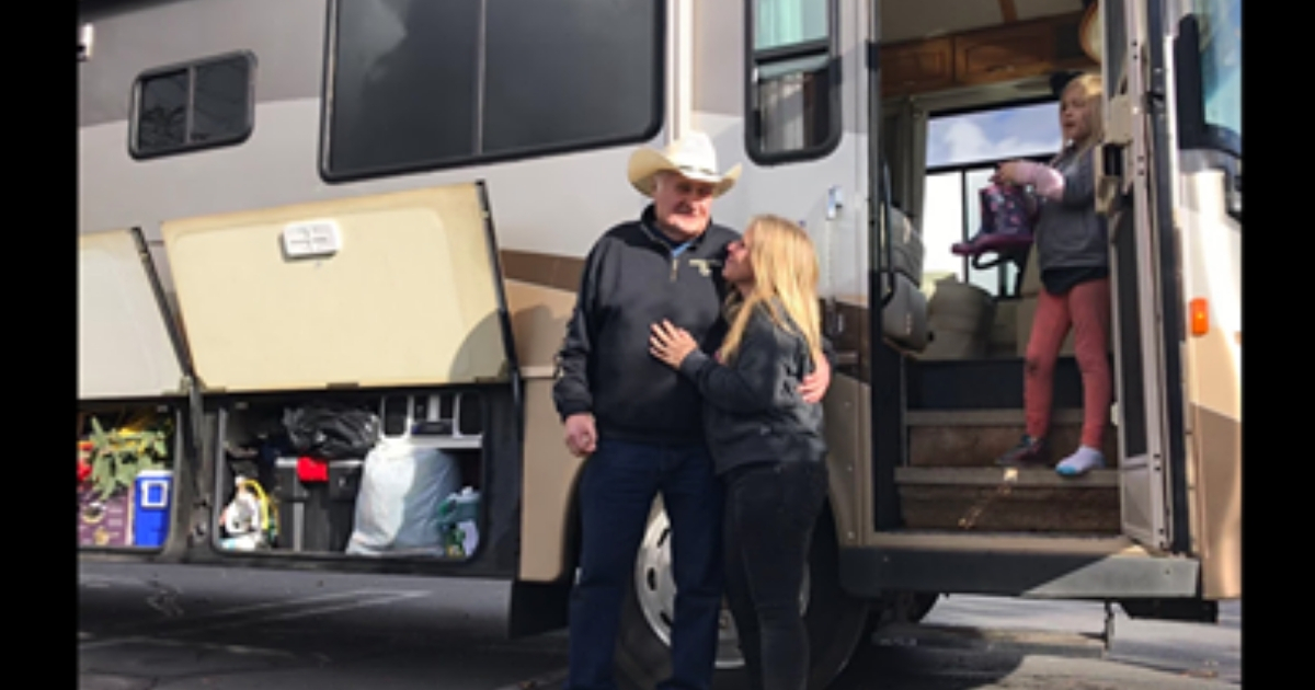 A man and woman stand in front of an RV