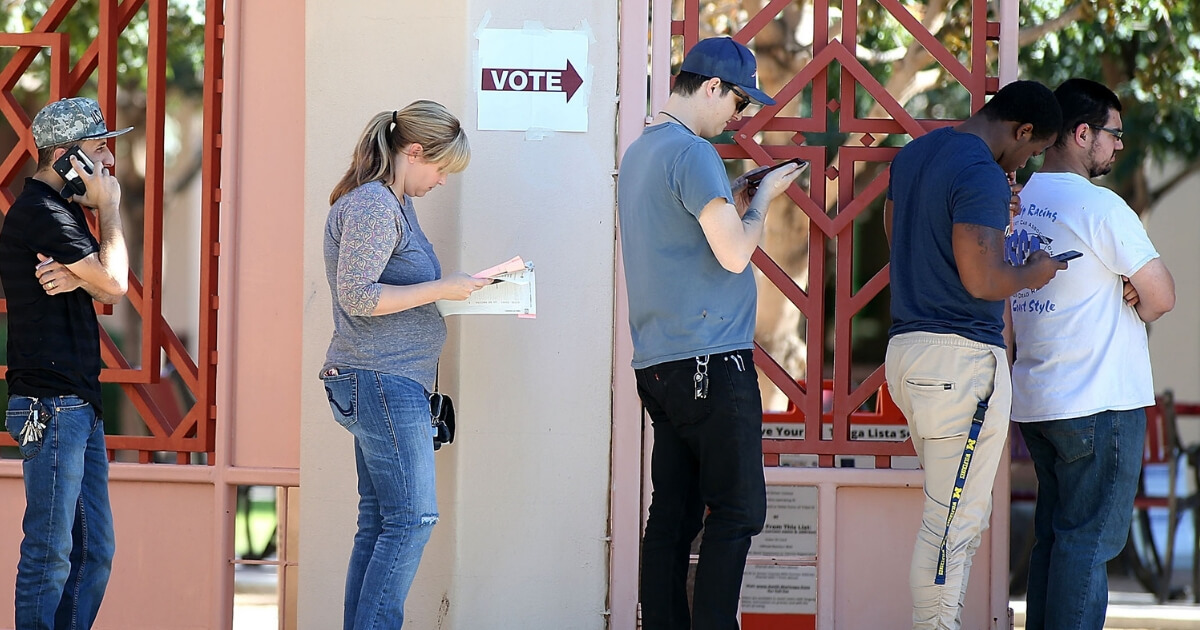 Arizona voters wait in line to cast their ballot at a polling place during the midterm elections on Nov. 6, 2018, in Phoenix, Arizona.