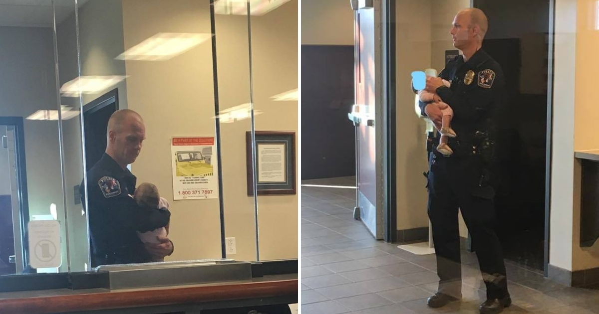 A police officer holds a mother's baby while she fills out paperwork.