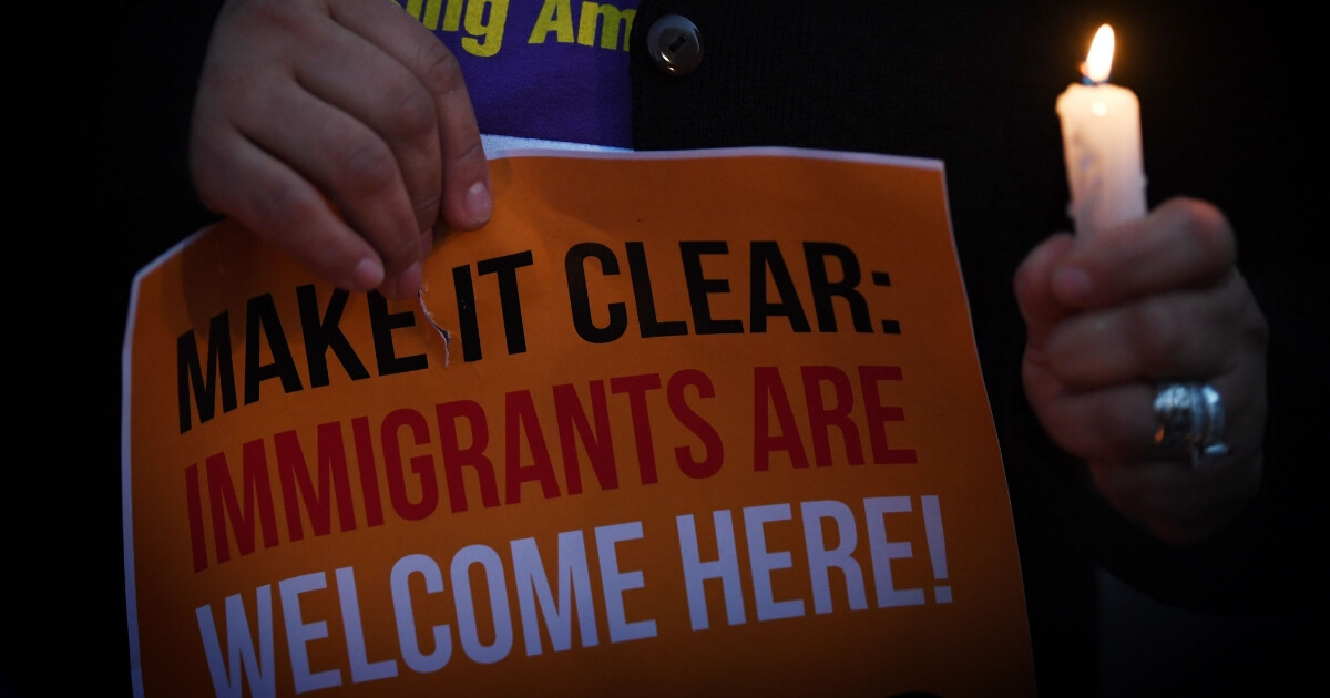 Migrant rights groups hold candles during a vigil to protest against US President Donald Trump's new crackdown on 'sanctuary cities'