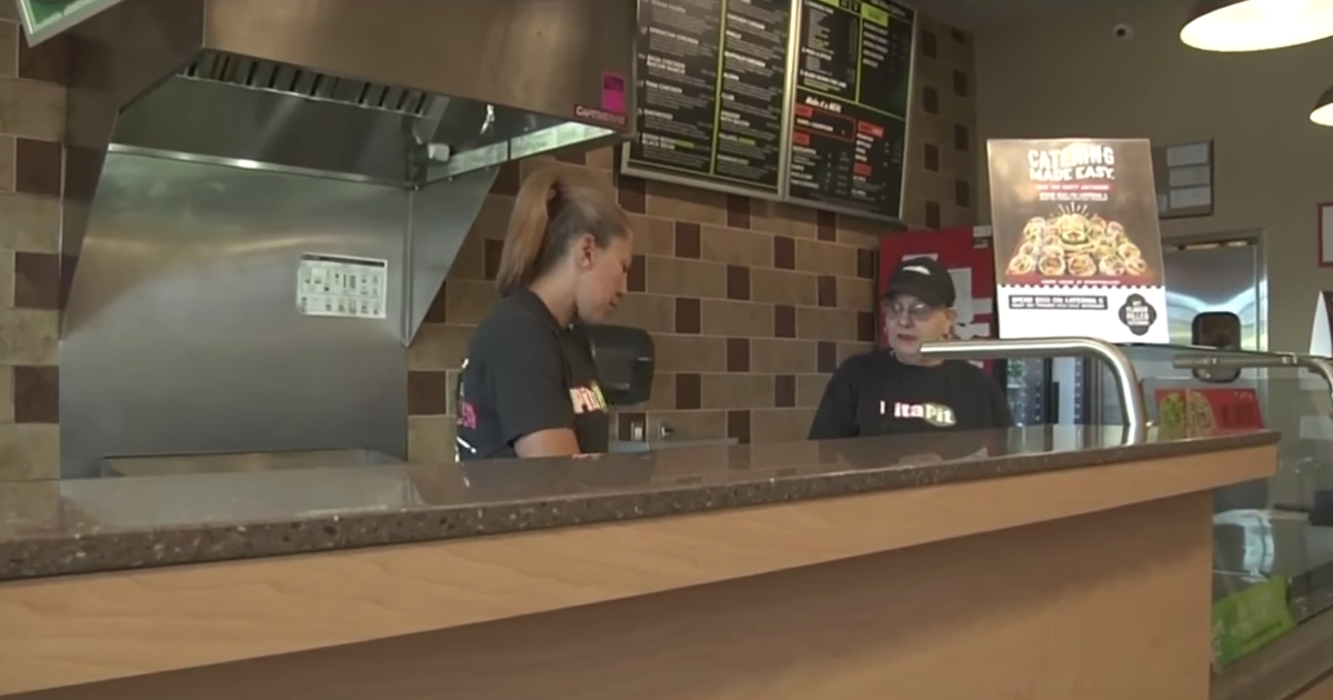 People working behind the counter at a Pita Pit
