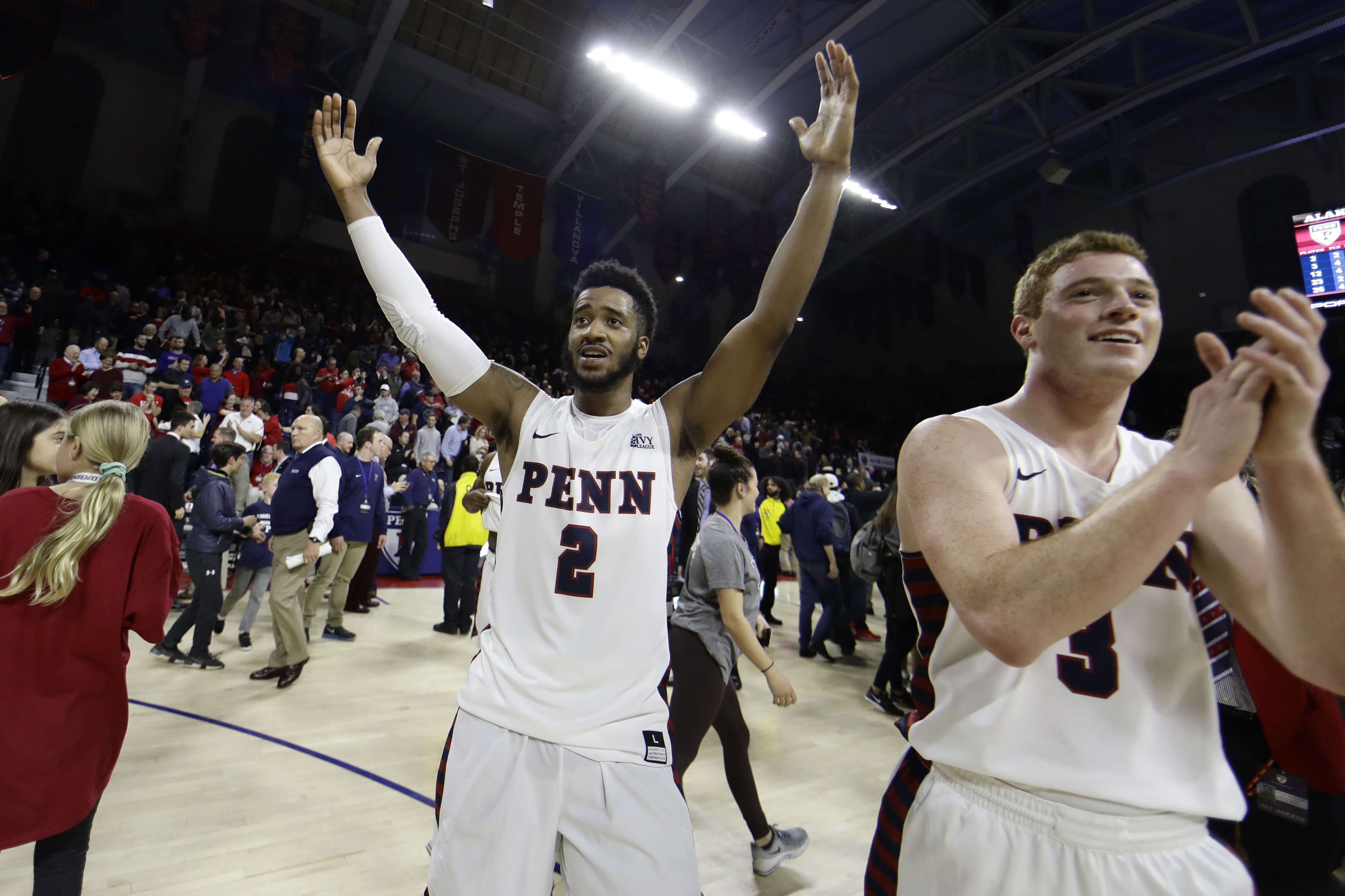 Penn's Antonio Woods (2) and Jake Silpe (3) celebrate after the Quakers beat Villanova 78-75 on Tuesday in Philadelphia.