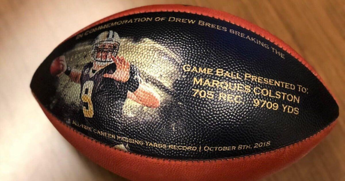 This undated photo provided by the New Orleans Saints shows a custom-made football. When Drew Brees became the NFL’s all-time leader in yards passing, he wanted to thank everyone who helped him get there. His solution was an exhaustive process that involved the production of about 175 unique commemorative footballs and the enlisting Saints front office and public relations staff to help track down 99 receivers, 56 offensive linemen, 11 head or assistant coaches from his 18 pro seasons, as well as a few others Brees saw as instrumental in his success.