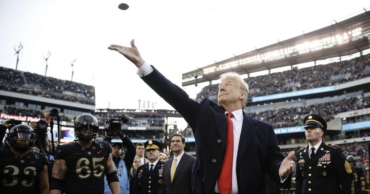 President Donald Trump tosses the coin before the Army-Navy football game Saturday in Philadelphia.