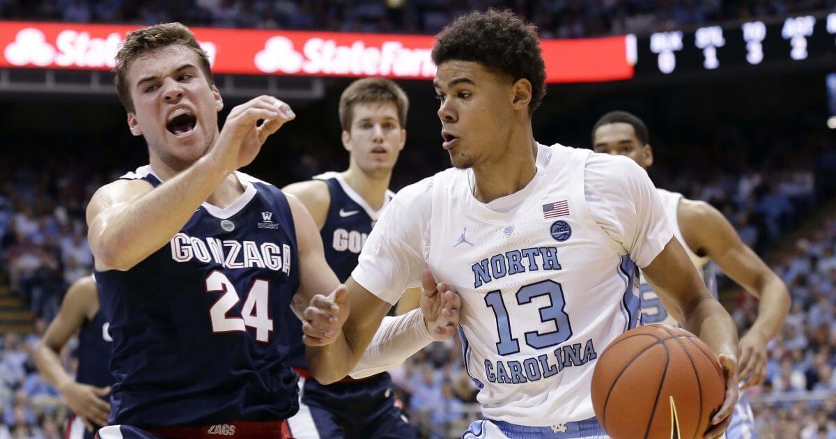 North Carolina's Cameron Johnson (13) dribbles the ball while Gonzaga's Corey Kispert (24) defends during the first half of an NCAA college basketball game in Chapel Hill, North Carolina, on Saturday.